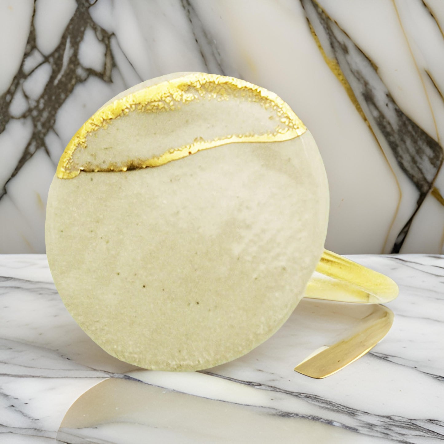 Zoom sur le médaillon de la bague blanc argile et or, détaillé et raffiné