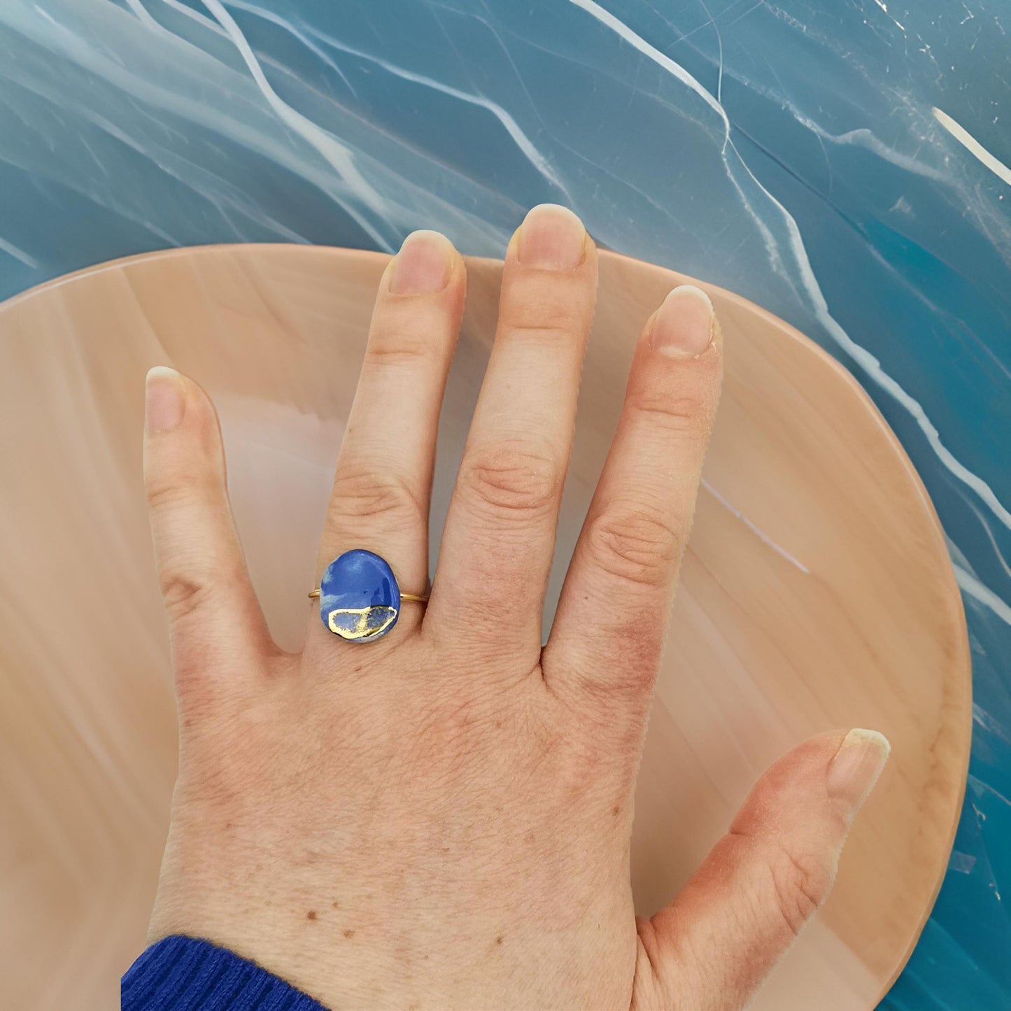 Bague artisanale en céramique bleu roi et or, présentée dans un élégant écrin rose