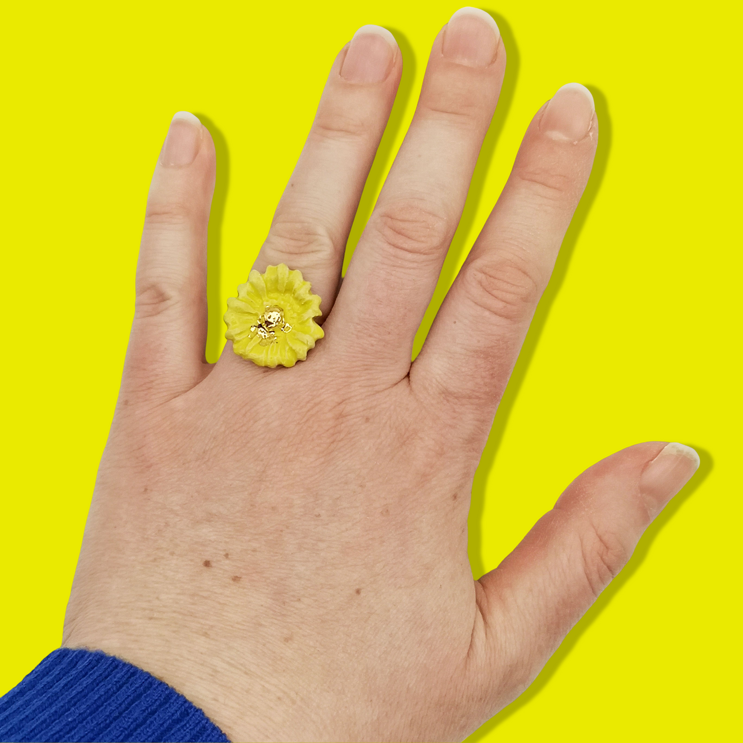 Bijou écoresponsable avec une fleur marguerite jaune éclatante, idéal pour un cadeau pensé avec soin.