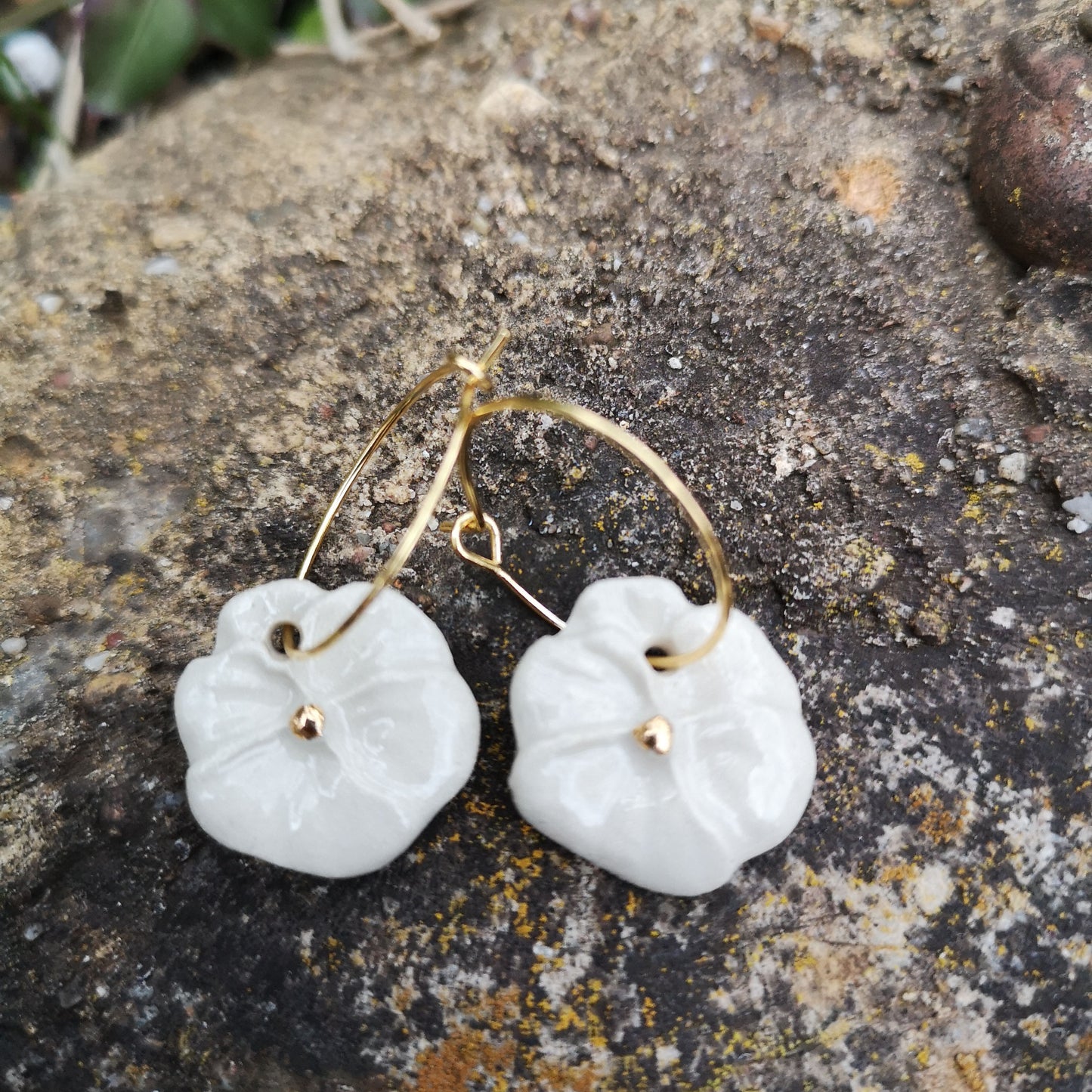 Bijou artisanal : boucles d'oreilles pensées blanches en céramique, façonnées à la main avec des finitions en or éclatant.