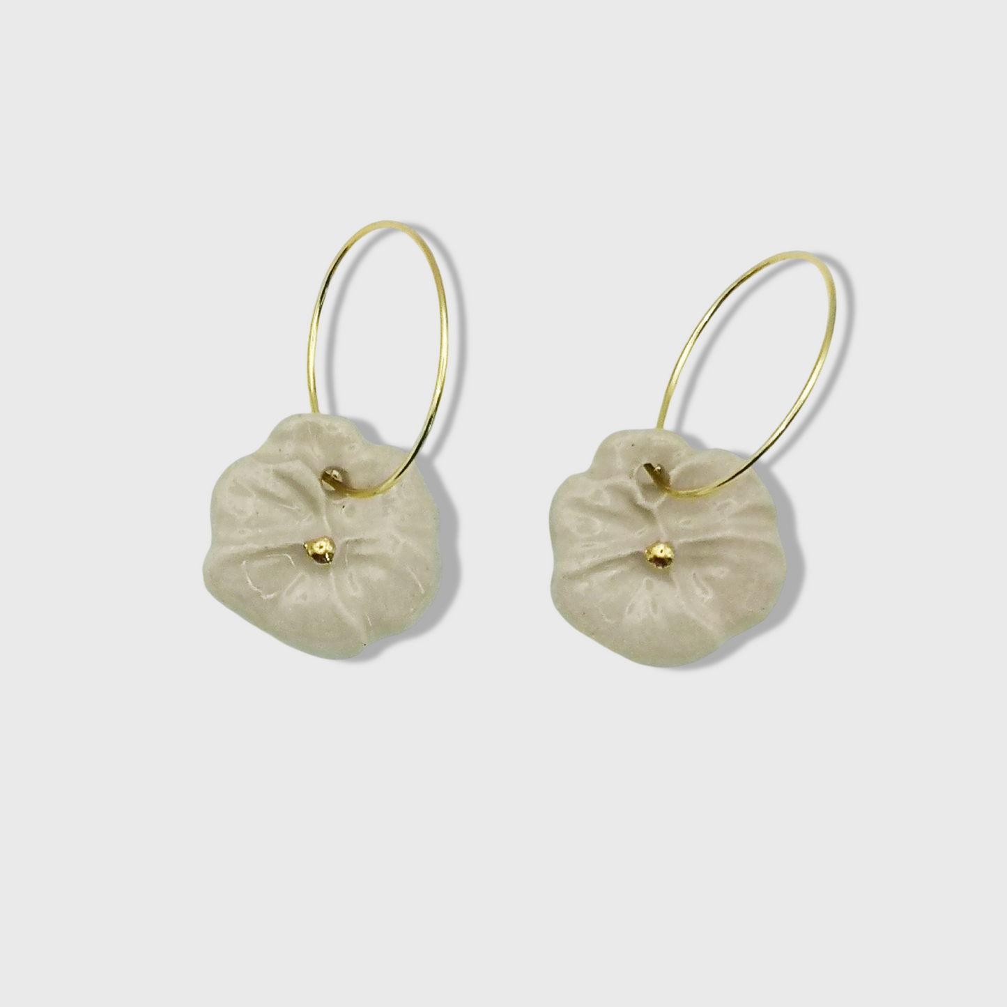 Élégantes boucles d'oreilles créoles avec fleurs pensées blanches et touches d’or, un bijou raffiné et intemporel.