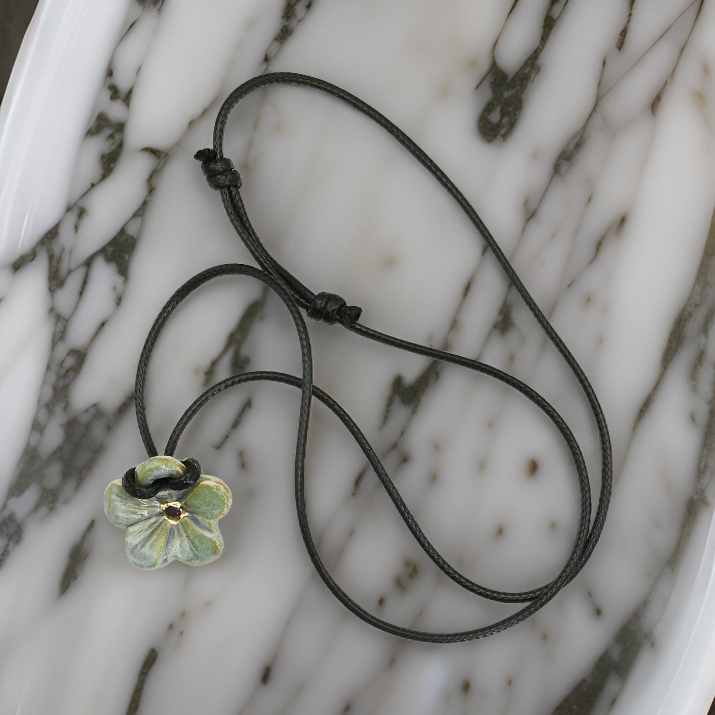 Collier hibiscus bleu et or, bijou élégant avec cordon en cuir, parfait pour offrir