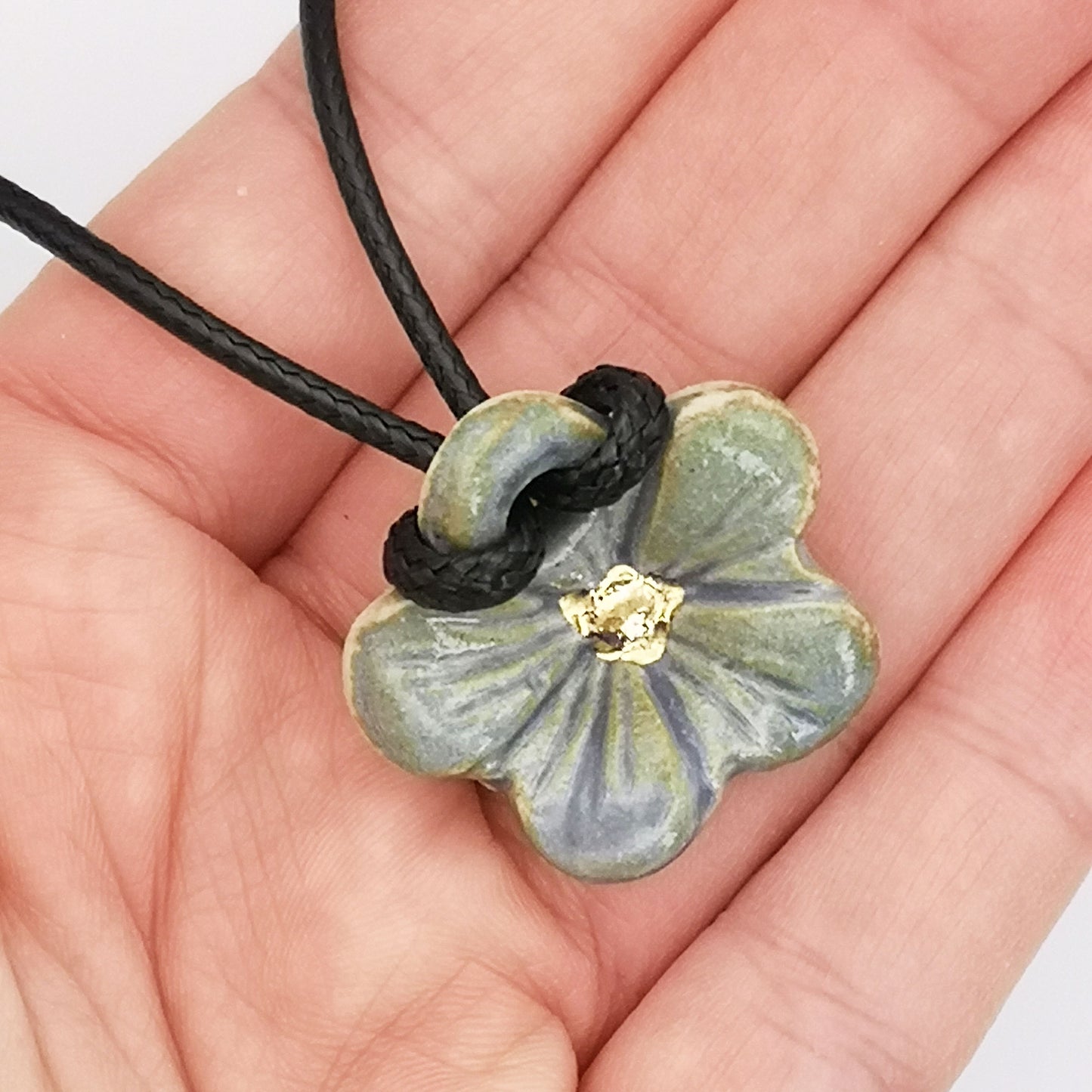 Photo de collier fleur hibiscus bleu et or, avec cordon en cuir, parfait comme cadeau