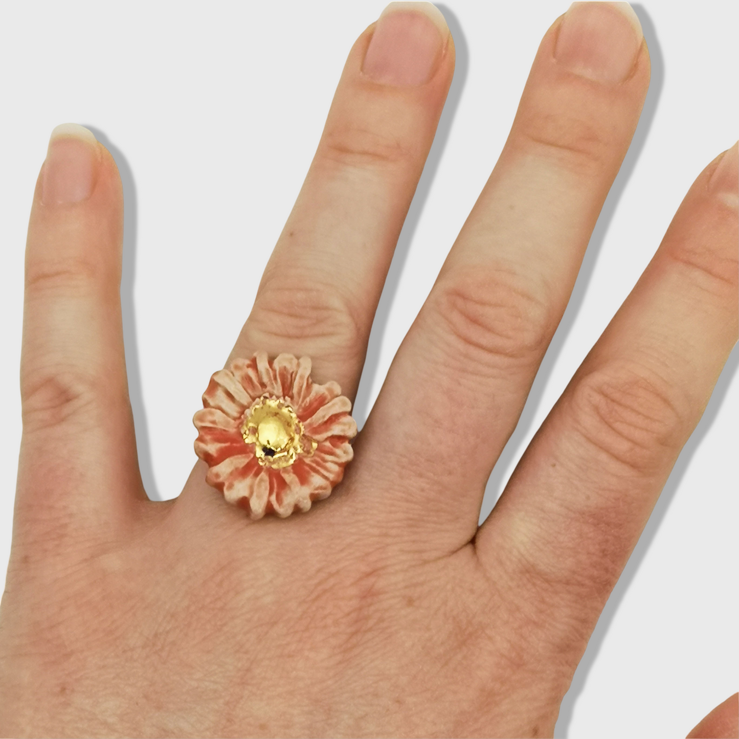 Image de la bague marguerite rouge corail et or, avec détails délicats et raffinés