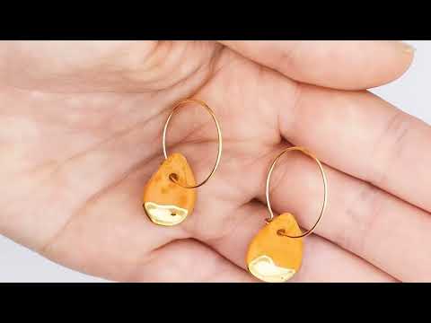 Boucles d'oreilles pendantes goutte d'eau en céramique orange et or pour femme, faites à la main en France. Élégantes et légères, parfaites pour une touche de couleur raffinée.
