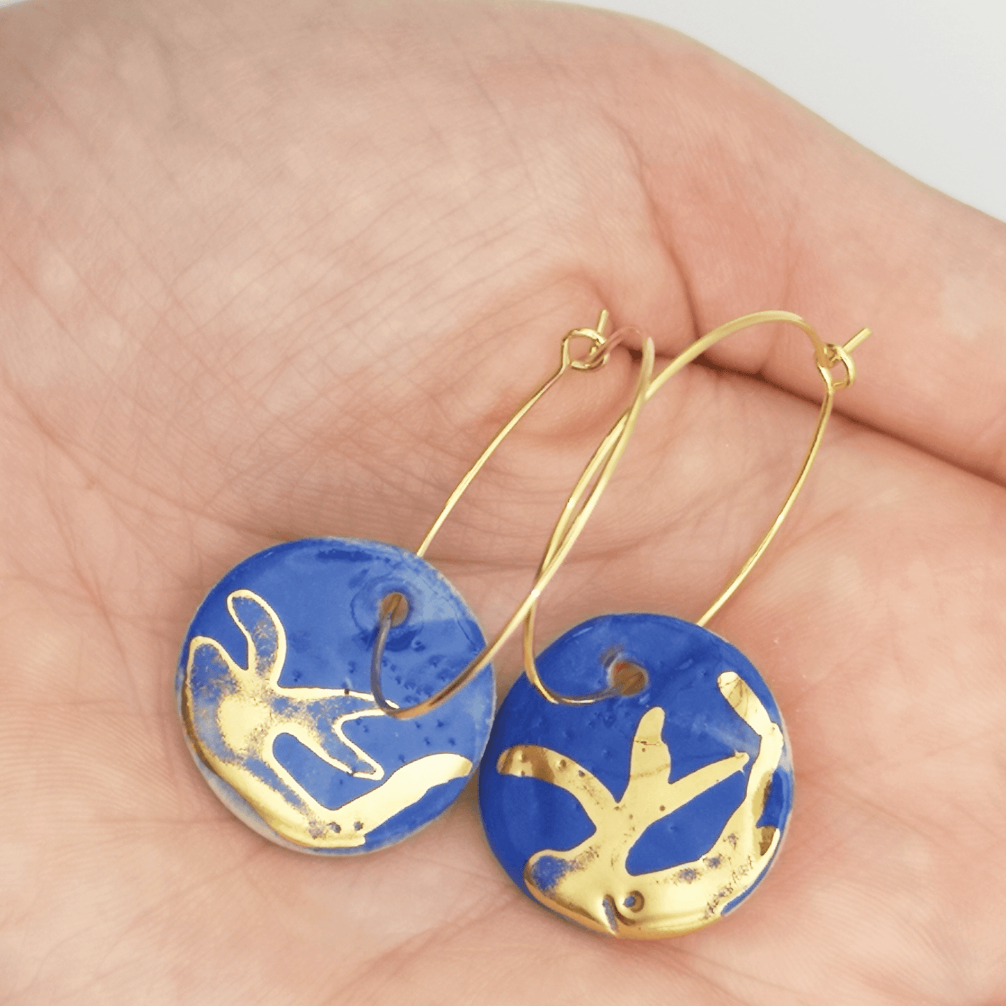 Boucles d'oreilles bleus Klein dans main