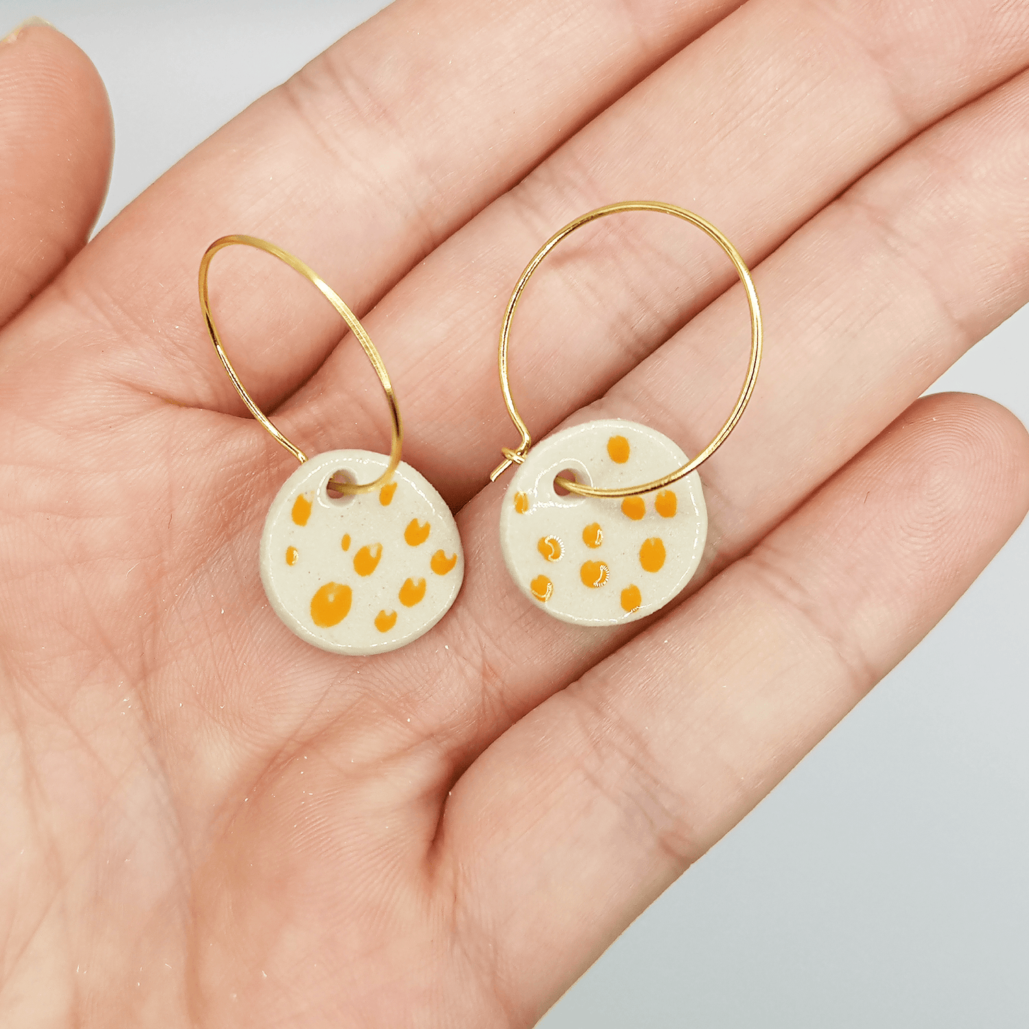 Boucles d'oreilles blanche pendante or a pois orange