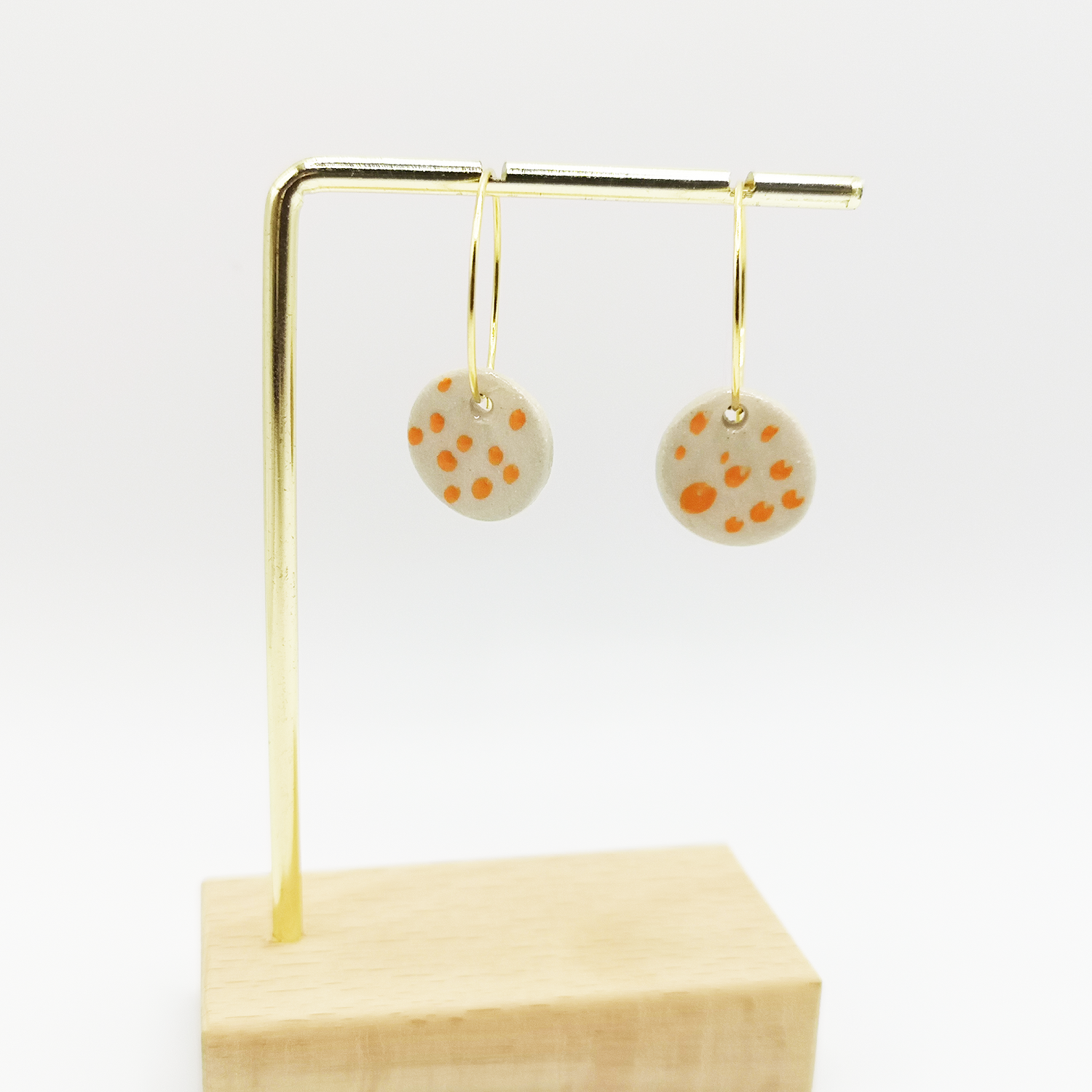 Boucles d'oreilles blanches unique a pois orange pendante sur support dore