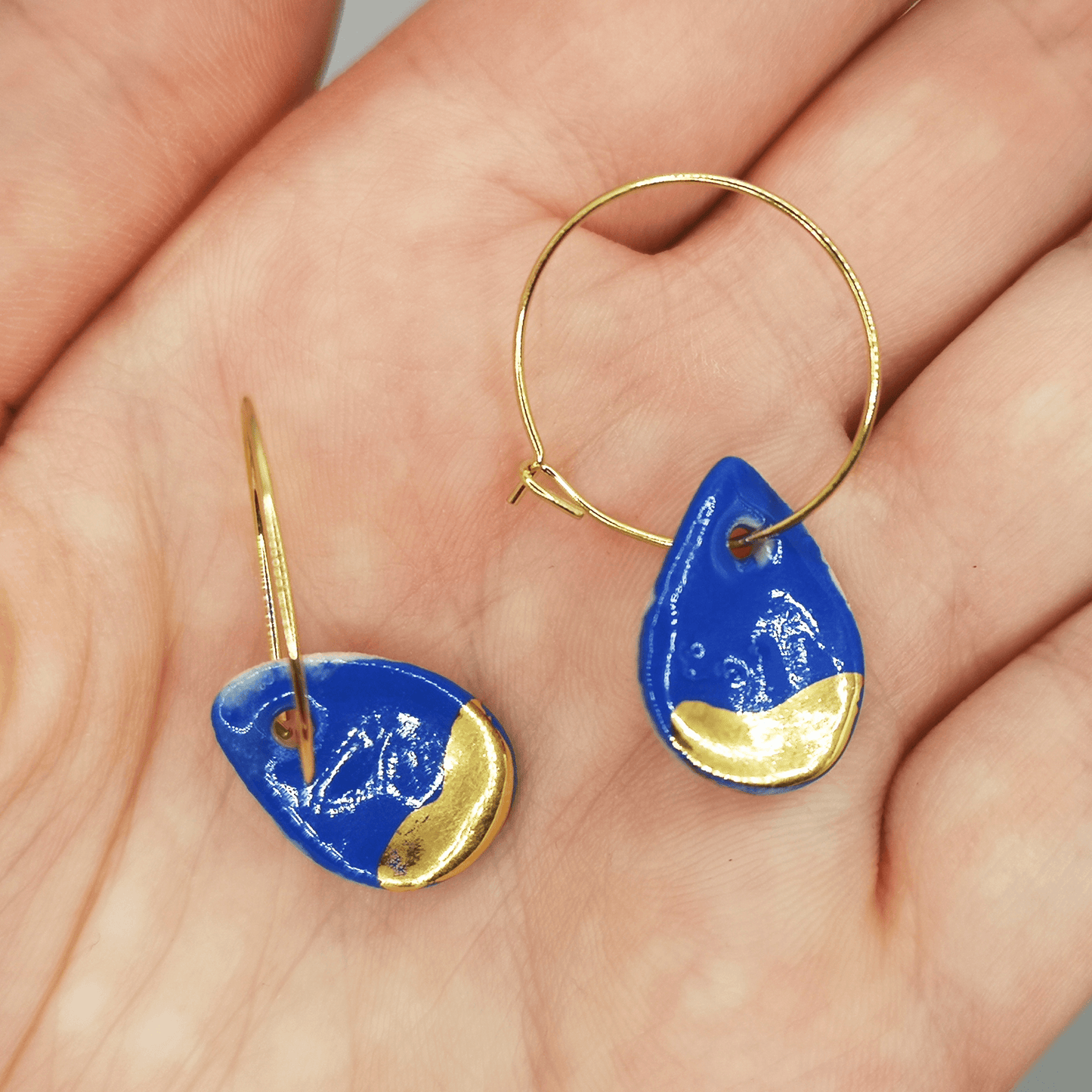 Boucles d'oreilles gouttes bleu Klein dans main