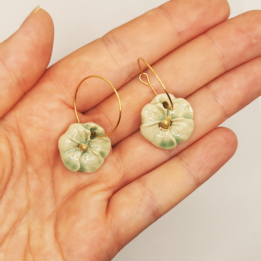 Bijoux artisanaux en céramique : créoles en laiton doré à l'or fin, avec pendentifs floraux Pensées vert céladon, livrés dans une élégante boîte cadeau rose.