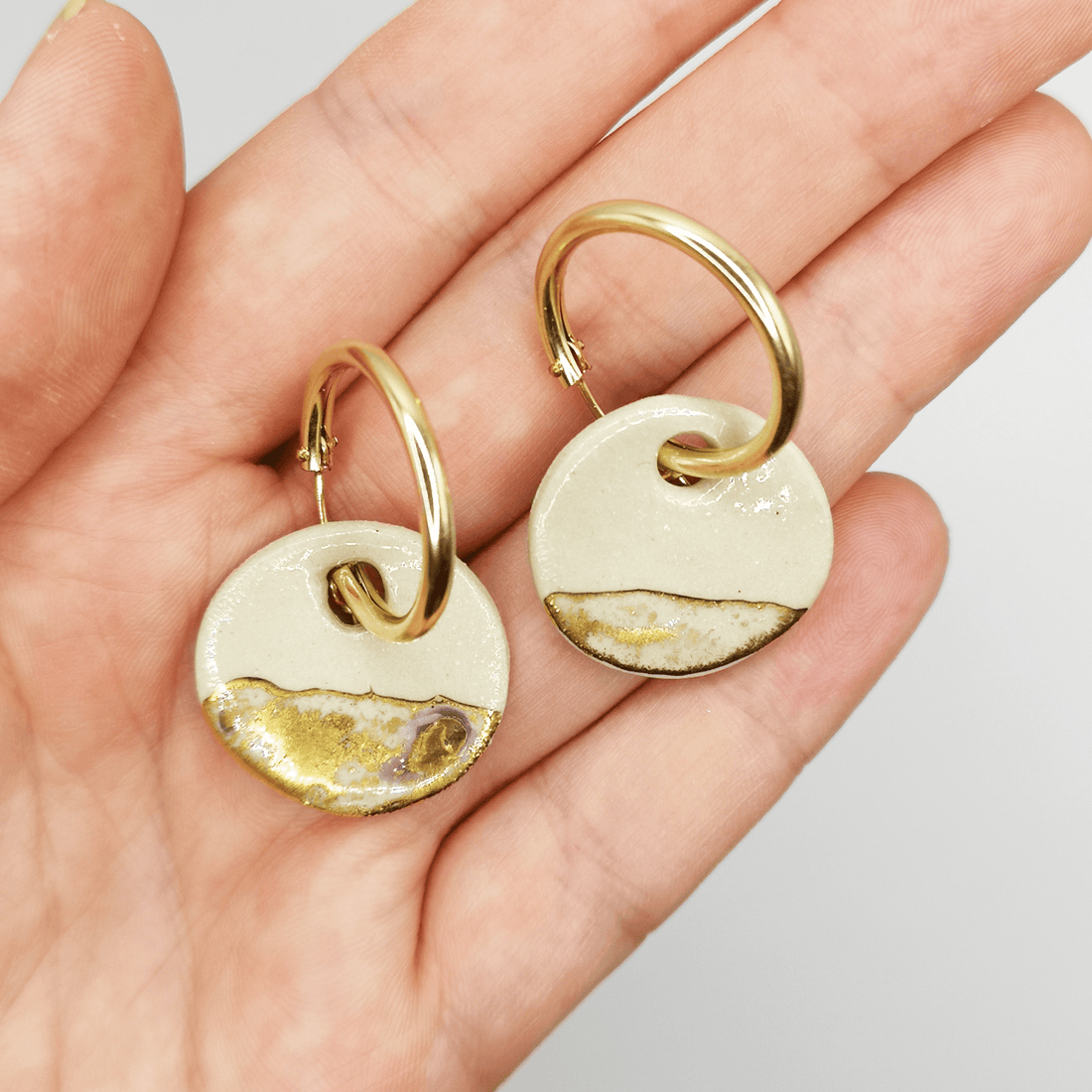Photo de boucles d'oreilles médaillons en argile blanche et or, avec anneaux gold filled super luxe, élégantes et raffinées.