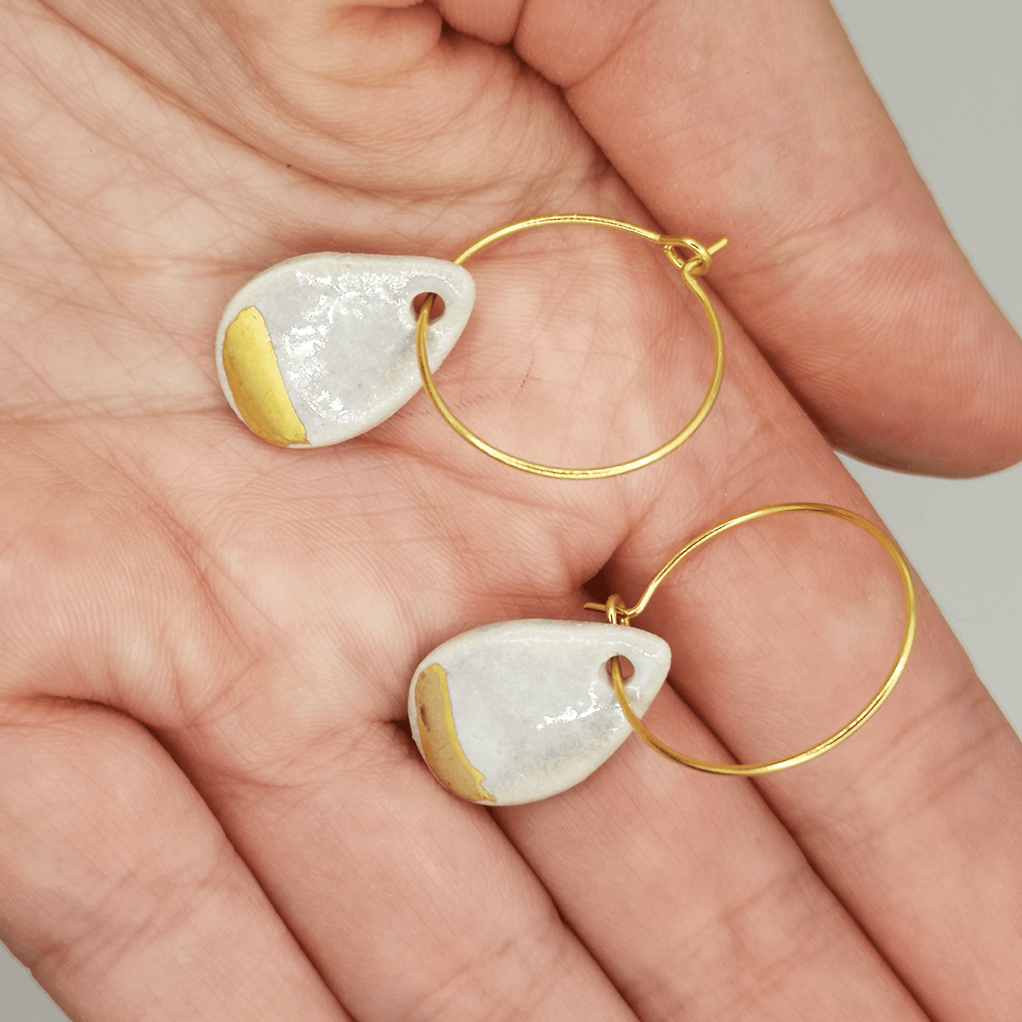 Boucles d'oreilles goutte d'eau blanc nacre or sur une anemetiste cadeau femme dans main Luxe