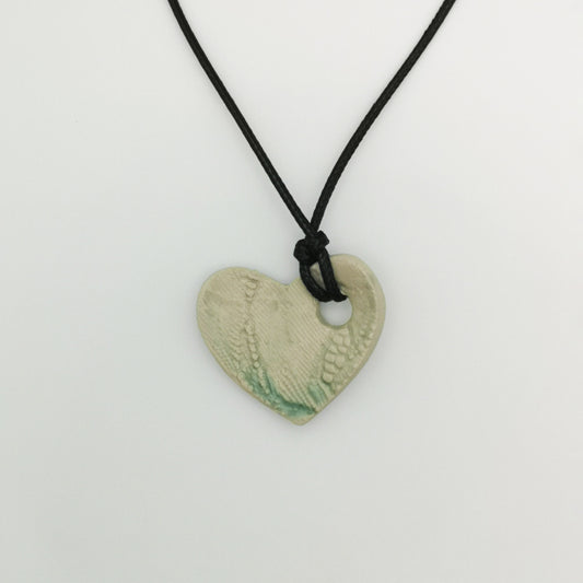 Collier cœur vert transparent avec motifs gravés et cordon cuir réglable, fabriqué à la main en Provence.