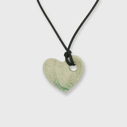 Collier cœur vert transparent avec motifs gravés et cordon cuir réglable, fabriqué à la main en Provence.