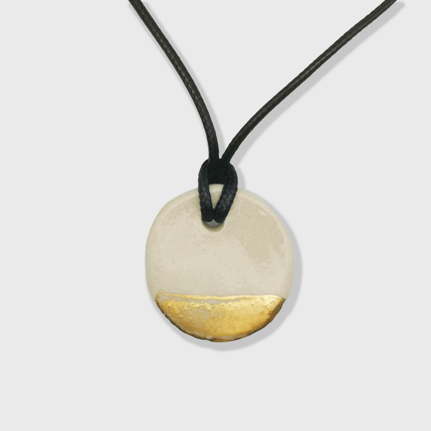 Collier blanc et or style minimaliste porté avec chemise blanche