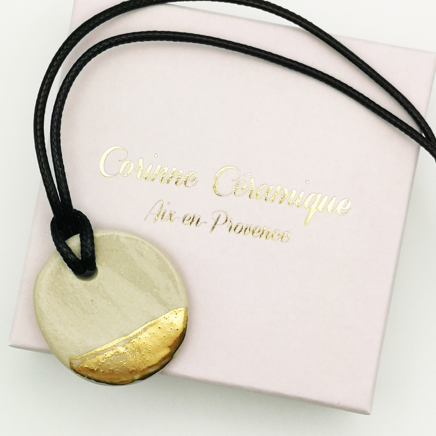 Collier artisanal blanc et or avec pendentif rond en céramique et lien cuir ajustable