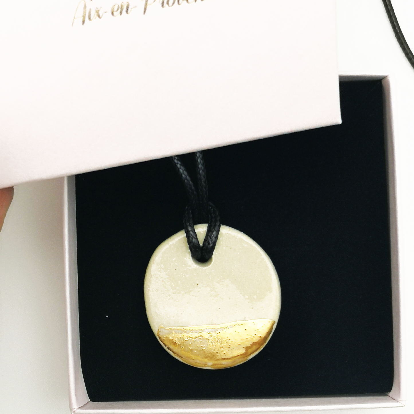 Médaillon en céramique blanc et or avec cordon cuir coulissant fabriqué à la main en Provence