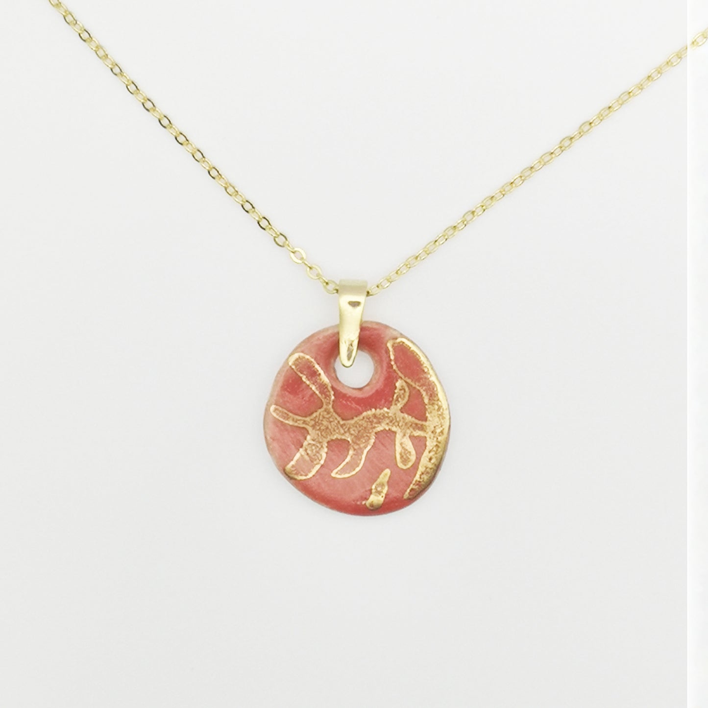 Collier Corinne Céramique avec pendentif rouge corail et branches en or véritable, symbole de beauté naturelle et d’artisanat français.