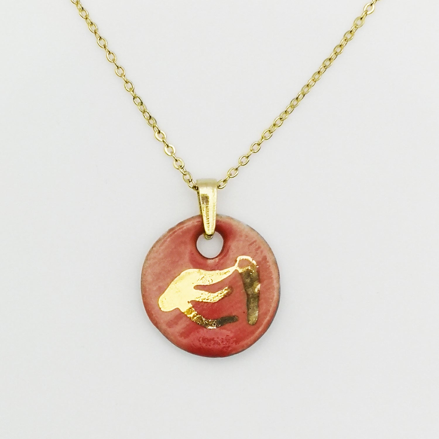 Collier artisanal en céramique rouge corail avec médaillon doré à l’or fin et design phénix