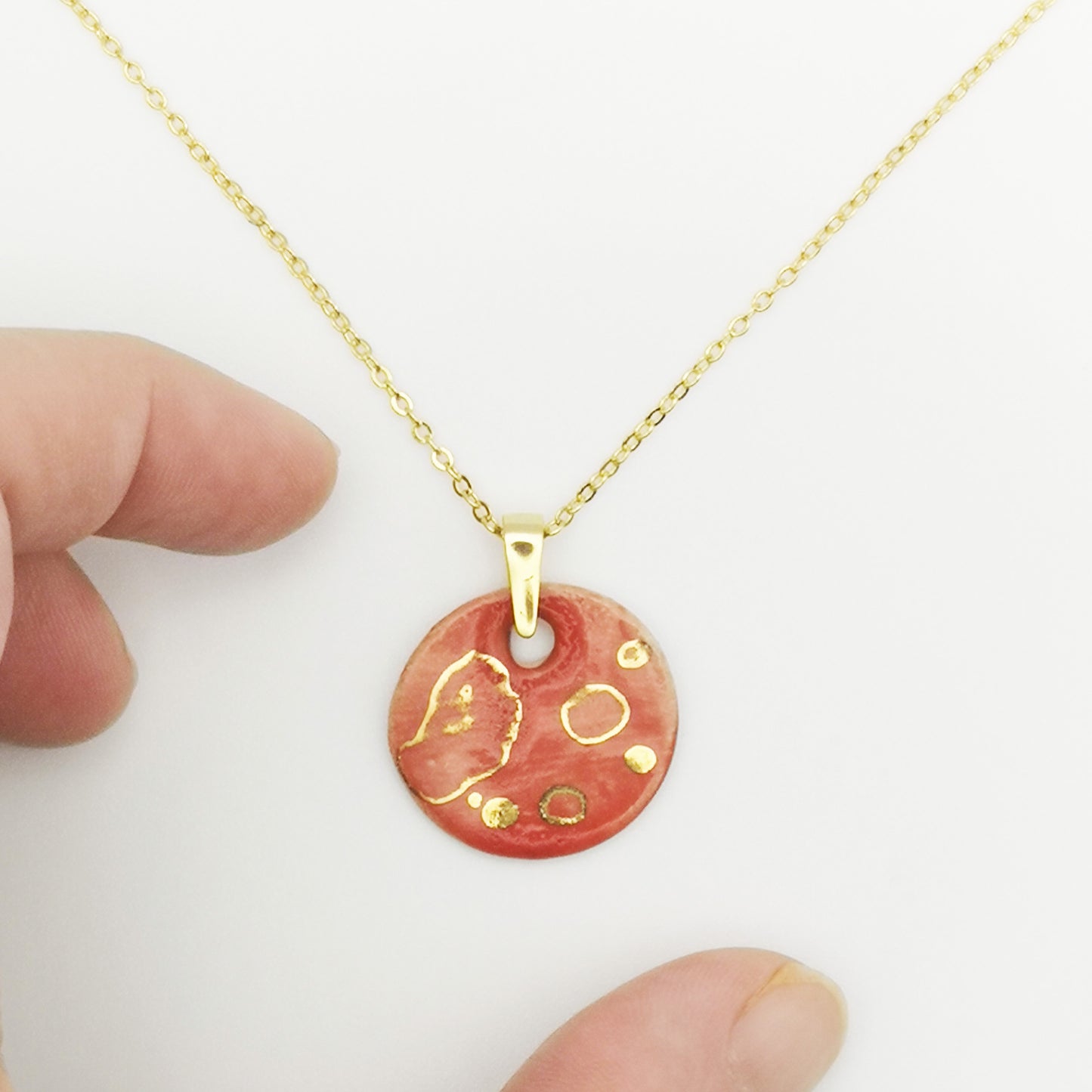 Collier médaillon rouge corail fait main avec pois dorés, bijou raffiné pour toutes les occasions, signé Corinne Céramique.