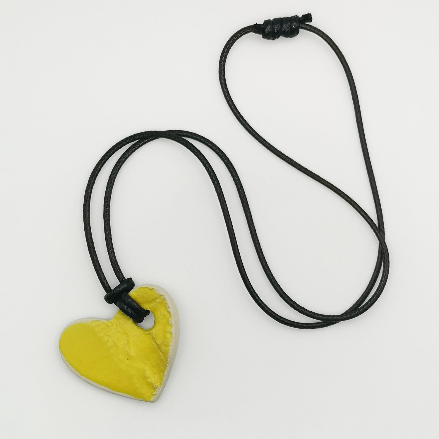 Collier cœur jaune de Corinne Céramique, artisanat français, soigneusement emballé dans une boîte cadeau rose.