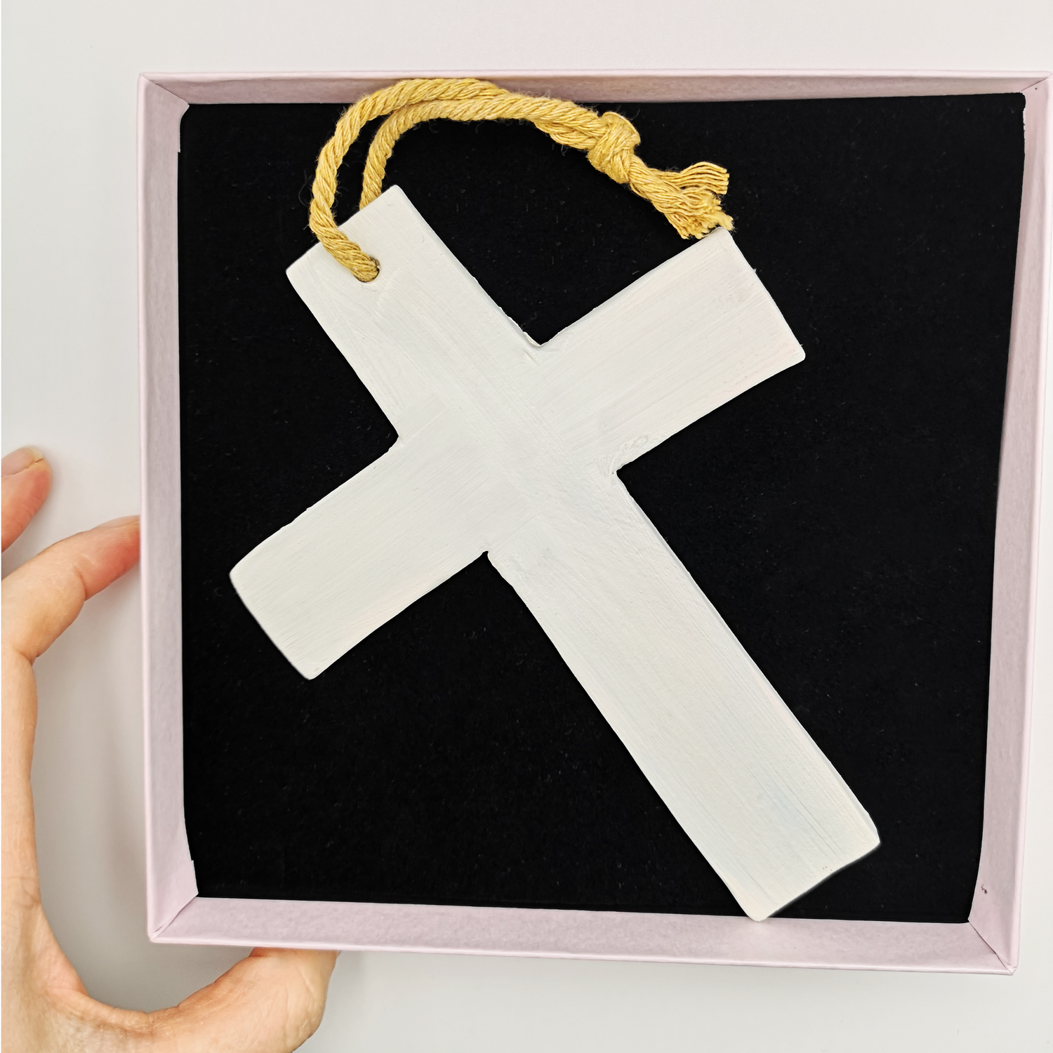 Croix blanche en céramique présentée dans un coffret luxe rose pâle Corinne Céramique, idée cadeau baptême