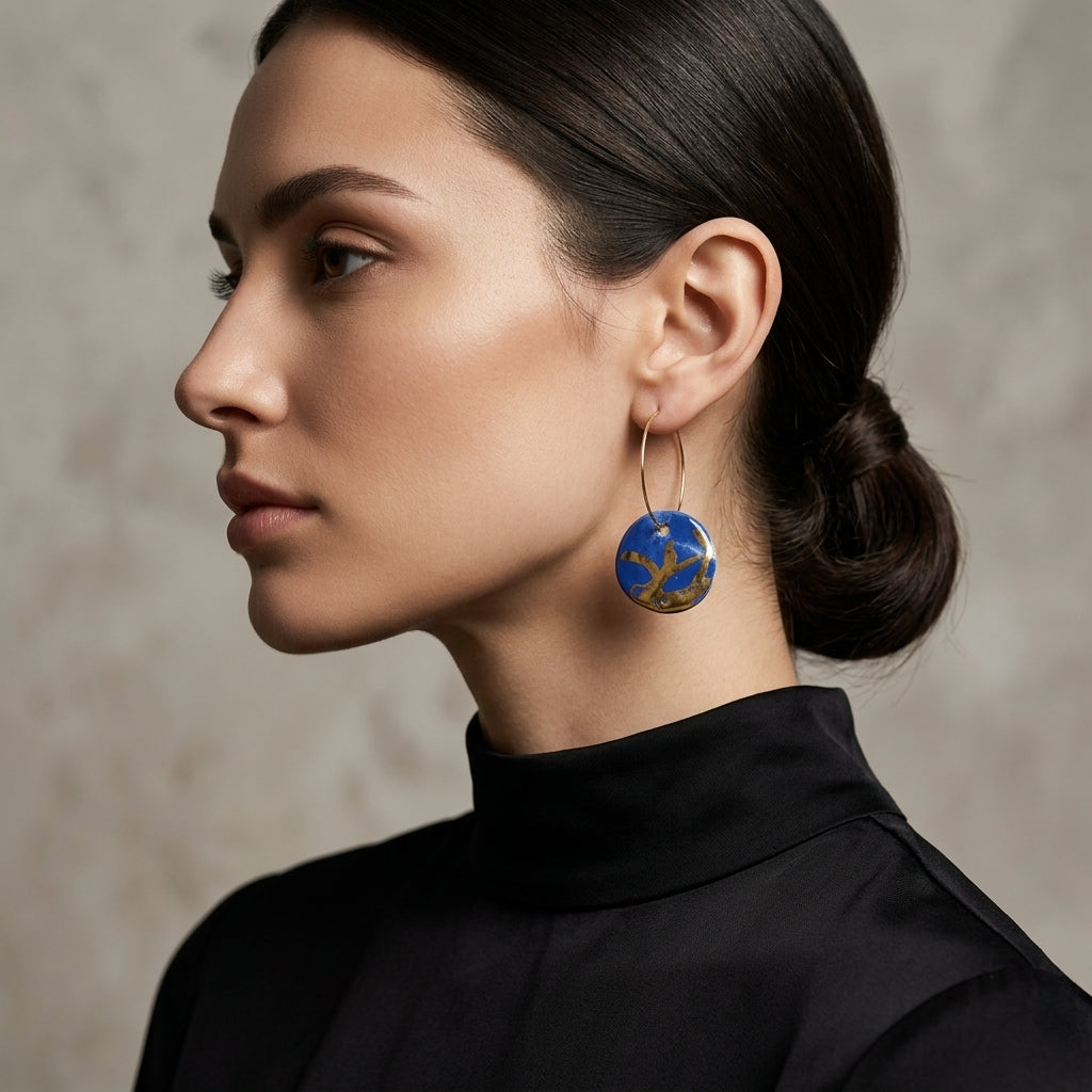 Boucles d'oreilles créoles bleu Klein en céramique avec pendentifs algues inspirés de Matisse, portées en gros plan