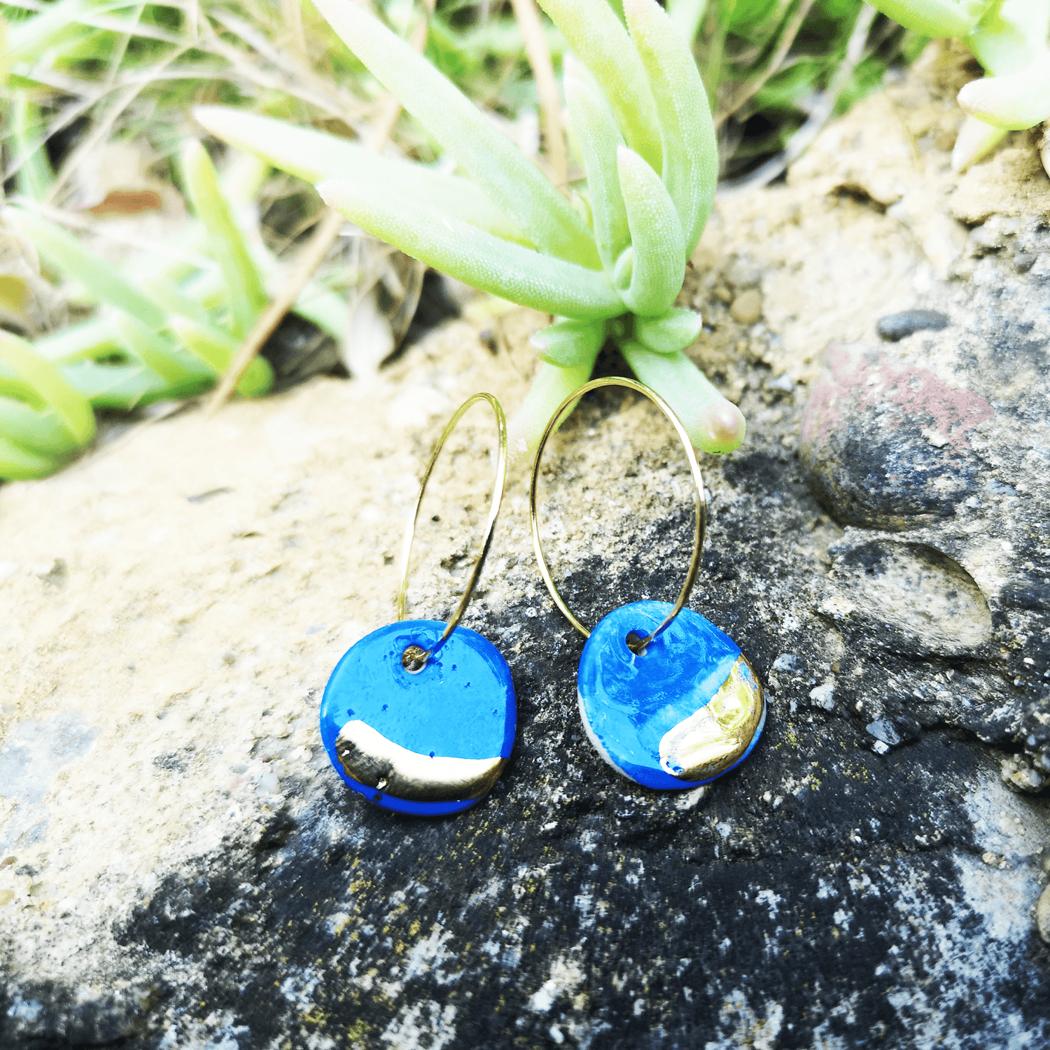 Boucles d'oreilles bleus Klein sur un rocher dans la nature eco responsable